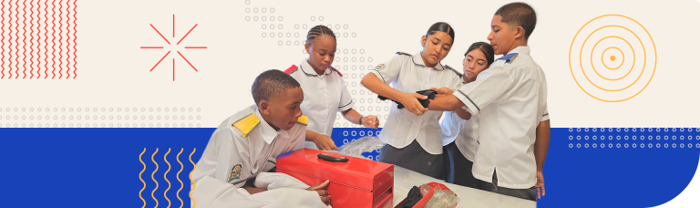 Group of students in uniform collaborating on a prototype device, representing an example of inclusive innovation to support communication for people with hearing loss.