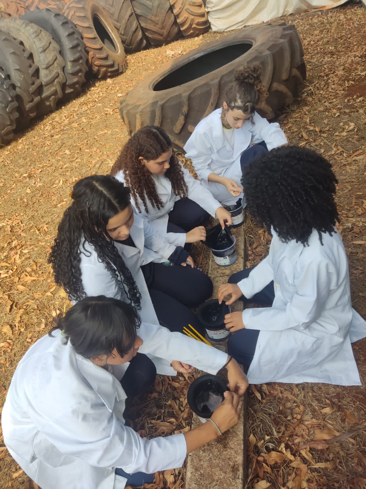 Estudantes manipulam solução em atividade sobre dengue na escola