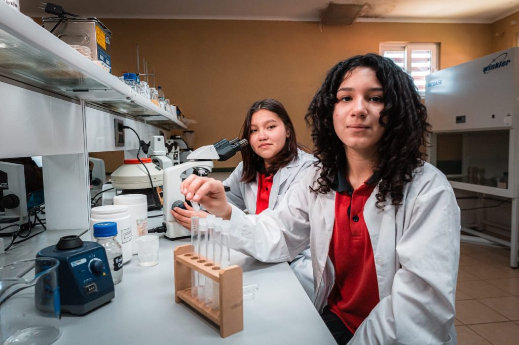 Estudiantes trabajan con tubos de ensayo en laboratorio escolar de biofertilizantes