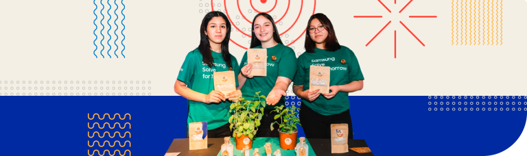 studiantes muestran microcápsulas biofertilizantes y plantas en mesa de proyecto escolar